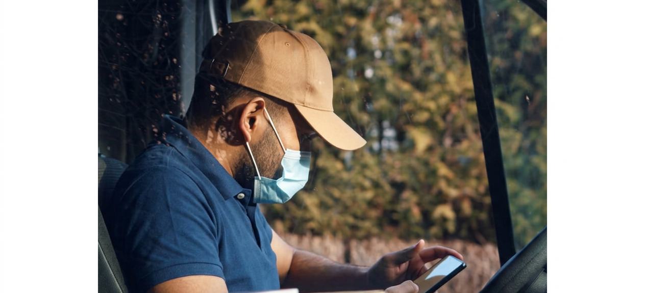Courier checking delivery details on a mobile phone