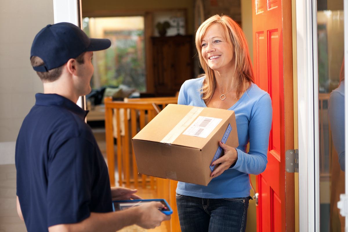 Courier delivering a parcel to a customer at home