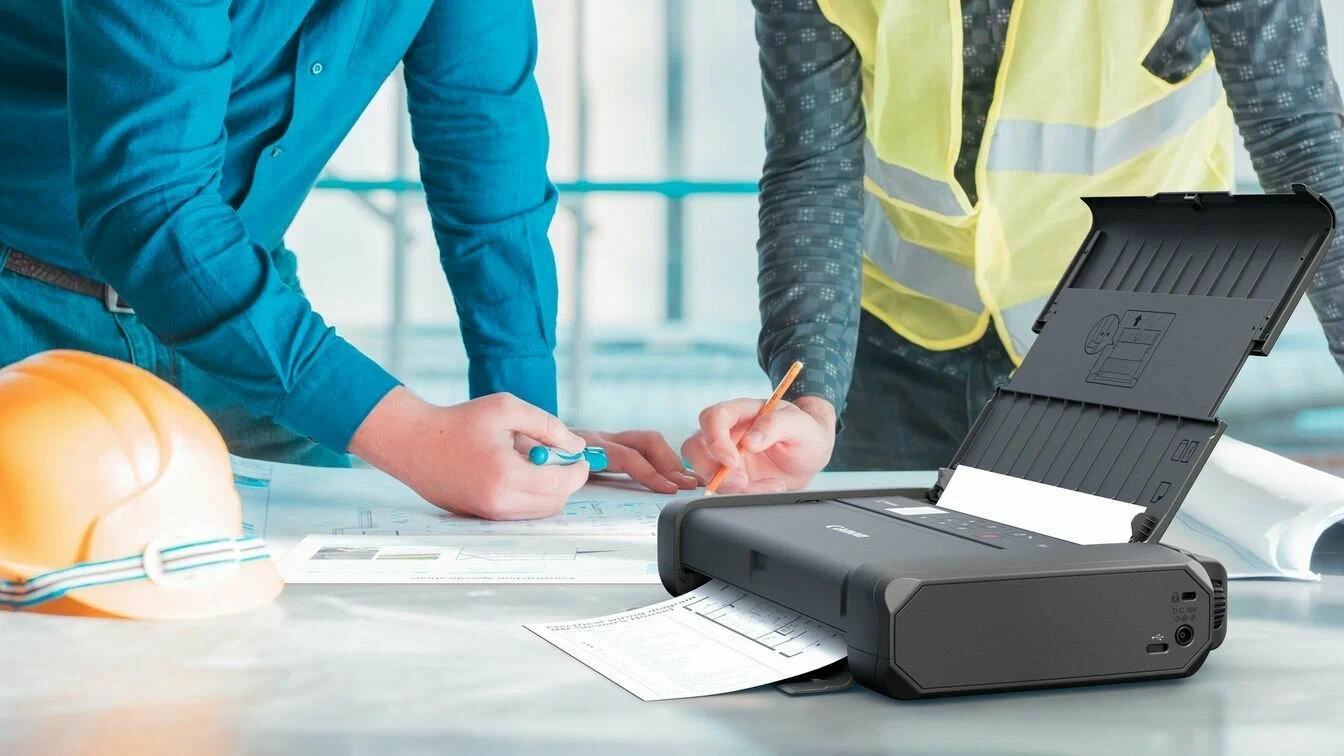 Workers using a portable printer with professional paperwork